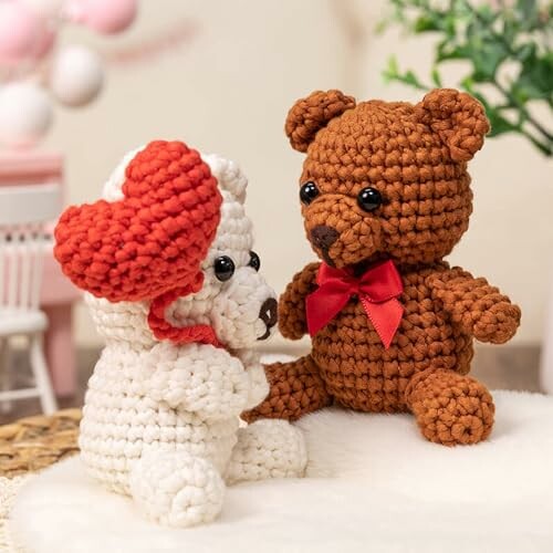 Two crochet bears, one brown with a red bow, and one white with a red heart.