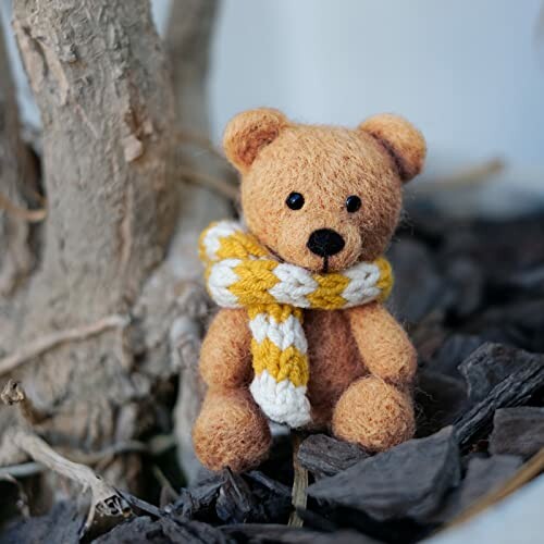 Felt teddy bear with a knitted scarf.