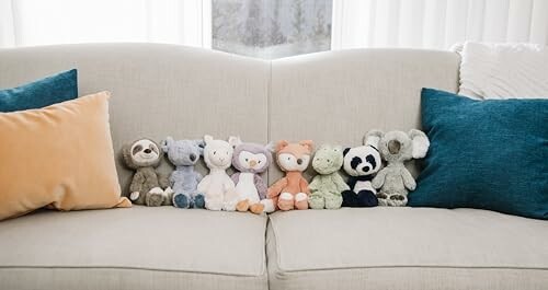 Stuffed animals lined up on a sofa.